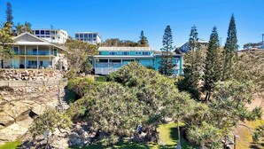 A coastal residential area with multiple houses, some with balconies, and a rocky landscape with sparse vegetation. - Silver Waters - Where Your Private Beach Awaits (Zilzie)