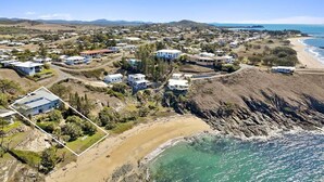 An aerial view of a coastal residential area with houses, a beach, and a rocky shoreline. - Silver Waters - Where Your Private Beach Awaits (Zilzie)