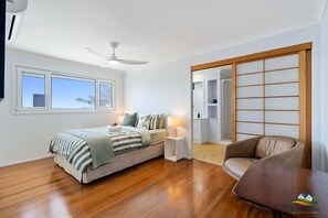 A bedroom with a bed, bedside table, lamp, and a view through a sliding door.