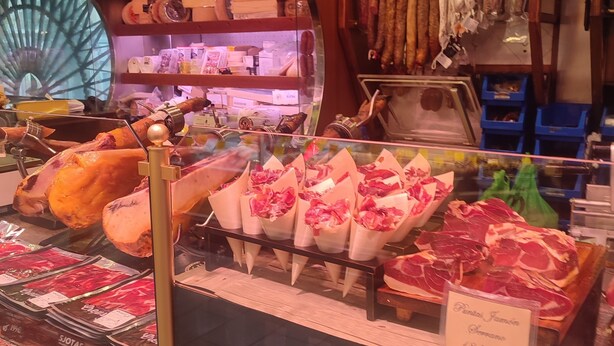 Mostrador de carnes con diferentes cortes y etiquetas de precios en una tienda.