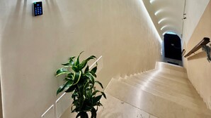 Et hotelreceptionsområde med et skilt, der viser 'Suites 102 103-104', en fjernbetjening og en potteplante.
