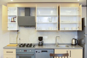 Eine moderne Küche mit Gasherd, Kaffeemaschine und Backofen.