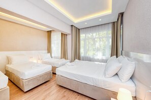 A hotel room with two beds, a large window with curtains, and a modern ceiling design. - Port Apart Hotel (Istanbul)