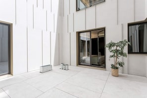 A modern interior with a large sliding glass door, a potted plant, and a minimalist design. - Elegant 3BD Apartment in Valladolid Solanilla II (Valladolid)