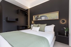 A modern bedroom with a large bed, a painting, built-in shelves, and a bedside table with a plant. - Bright Apartment in the Heart of Valladolid Solanilla IV (Valladolid)