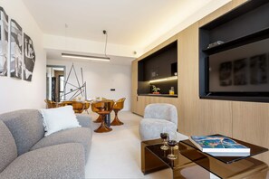 A modern living room with a sofa, armchair, coffee table, and dining area with chairs. - Bright Apartment in the Heart of Valladolid Solanilla IV (Valladolid)