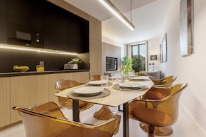 Un'area pranzo moderna con un tavolo imbandito per quattro persone, circondato da sedie dalla forma particolare.