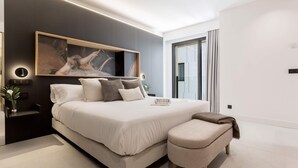 A modern bedroom with a large bed, bedside tables, a bench, and a painting on the wall. - Spectacular Apartment in Valladolid Center Solanilla III (Valladolid)