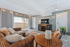 Een moderne woonkamer met een open haard, comfortabele zithoek en een televisie.