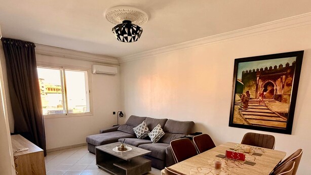 Una sala de estar moderna con sofá, mesa de centro, mesa de comedor y sillas.