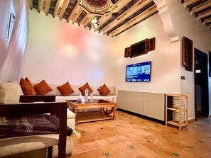 Ein Wohnzimmer mit Sofa, Couchtisch und Wandfernseher.