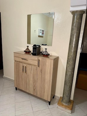 A wooden cabinet with drawers and a mirror above it, a metal column, and a tiled floor. - Family-friendly home in the city center, a 5-minute walk from the train station (Marrakesh)