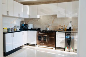 A modern kitchen with white cabinets, a stainless steel range, and a dishwasher. - A Luxurious, Modern, Central Gem + Netflix (Marrakesh)