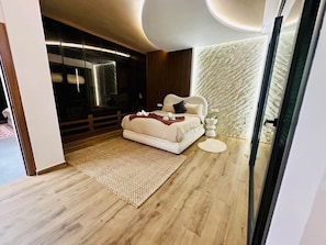 Ein modernes Schlafzimmer mit Bett, Nachttischen, Teppich und einer Wand mit Strukturmuster.