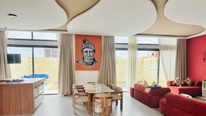 Un soggiorno moderno con un tavolo da pranzo, divani rossi e un'ampia finestra con vista.