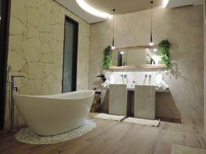 Ein modernes Badezimmer mit freistehender Badewanne, einem Doppelwaschtisch und einem großen Spiegel darüber.