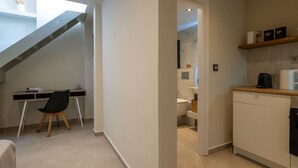 A modern interior with a desk, chair, and a staircase leading to an upper level. - Neilise - Modern Retreat in Central Kalamata (Kalamata)