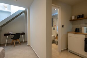 Un interior moderno con un escritorio, una silla y una escalera que conduce a un nivel superior.