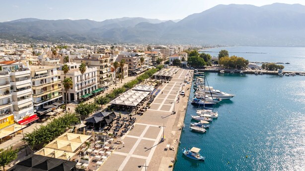 A coastal cityscape with a marina, buildings, and mountains in the background. - Neilise - Modern Retreat in Central Kalamata (Kalamata)