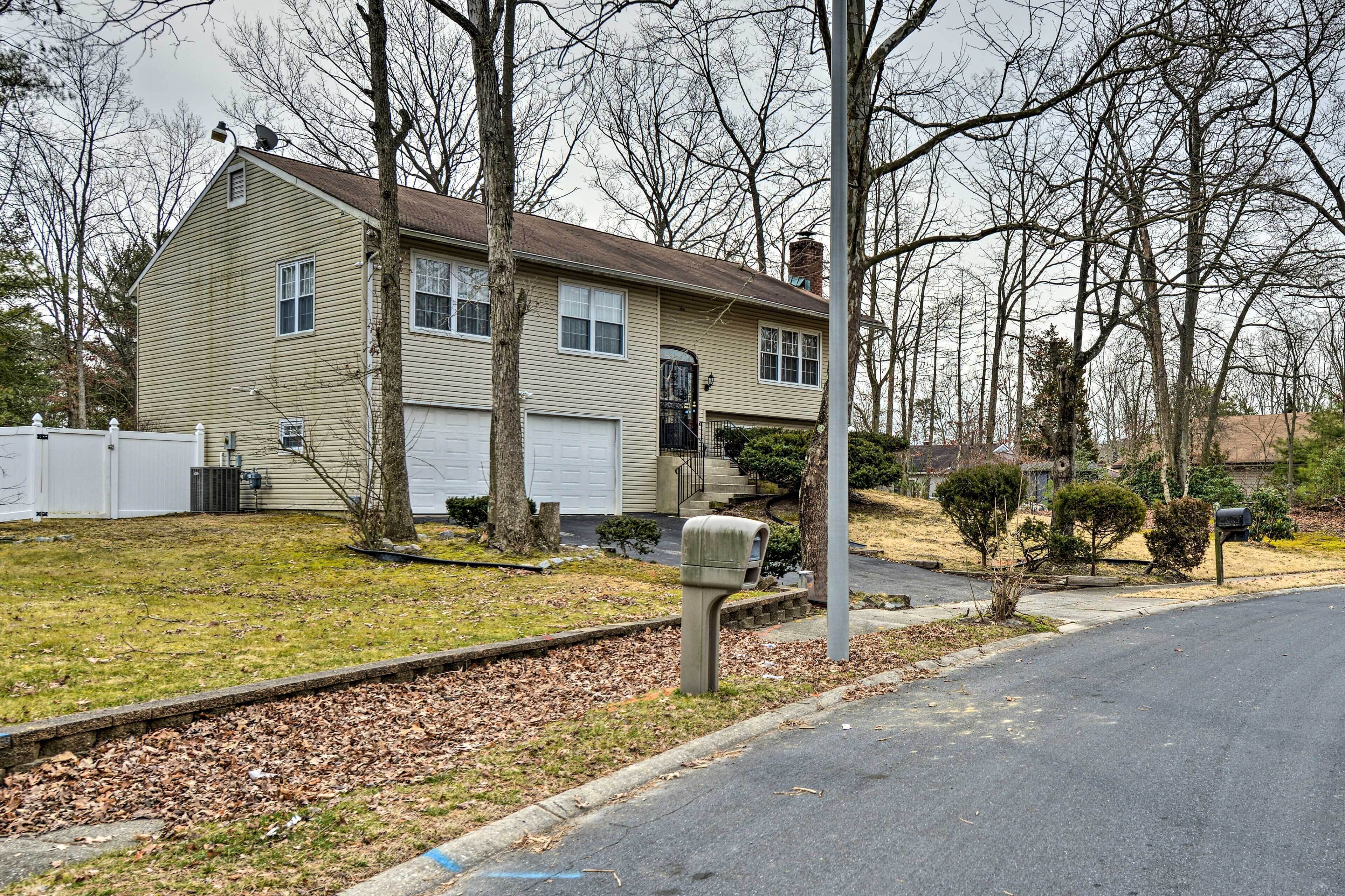 A two-story house with a garage, a front yard with a mailbox, and a street view.