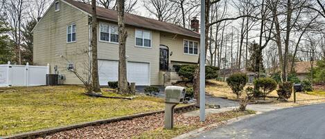 A two-story house with a garage, a front yard with a mailbox, and a street view.