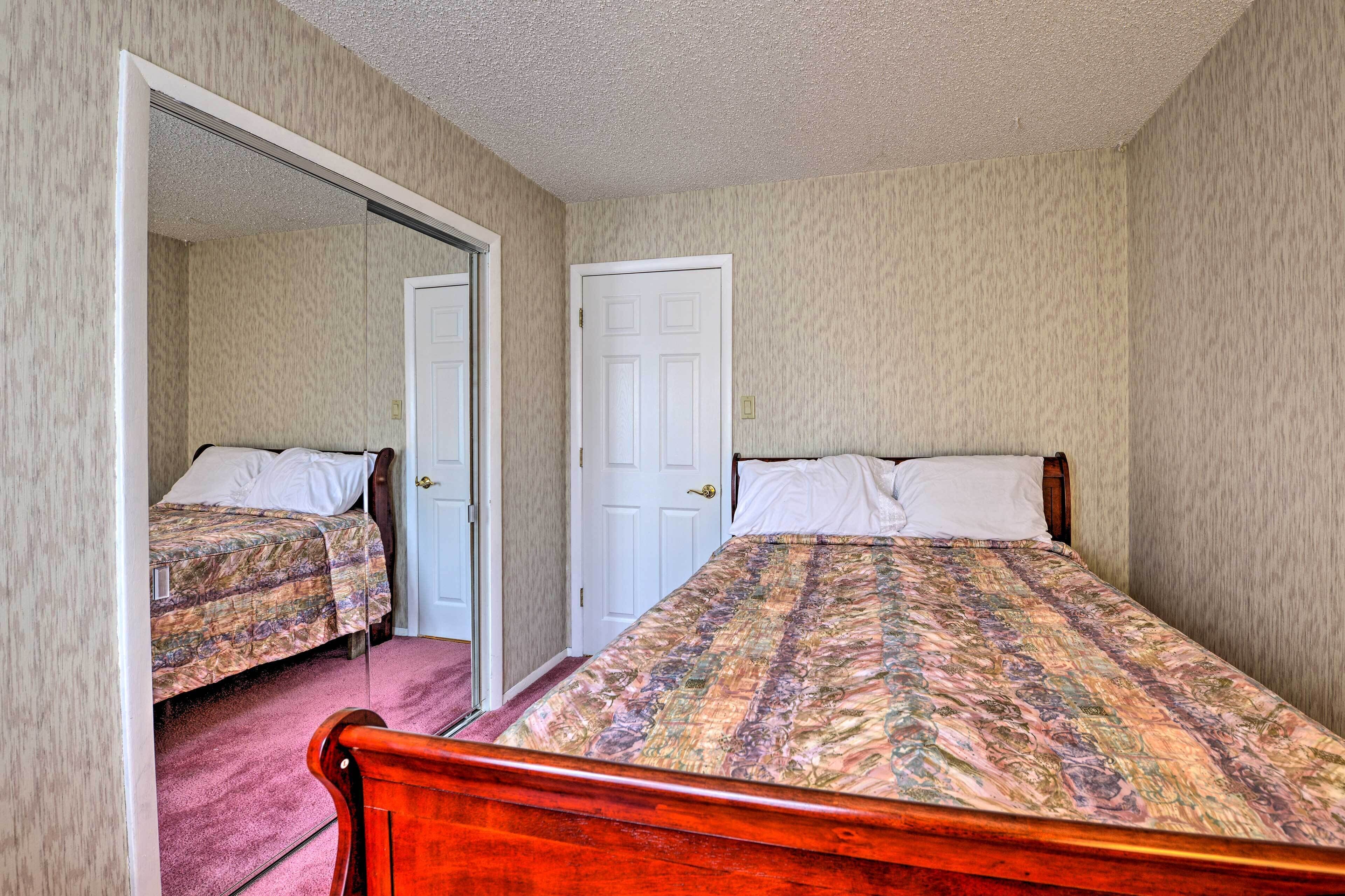 Ein Schlafzimmer mit zwei Betten, einer Tür und Teppichboden.
