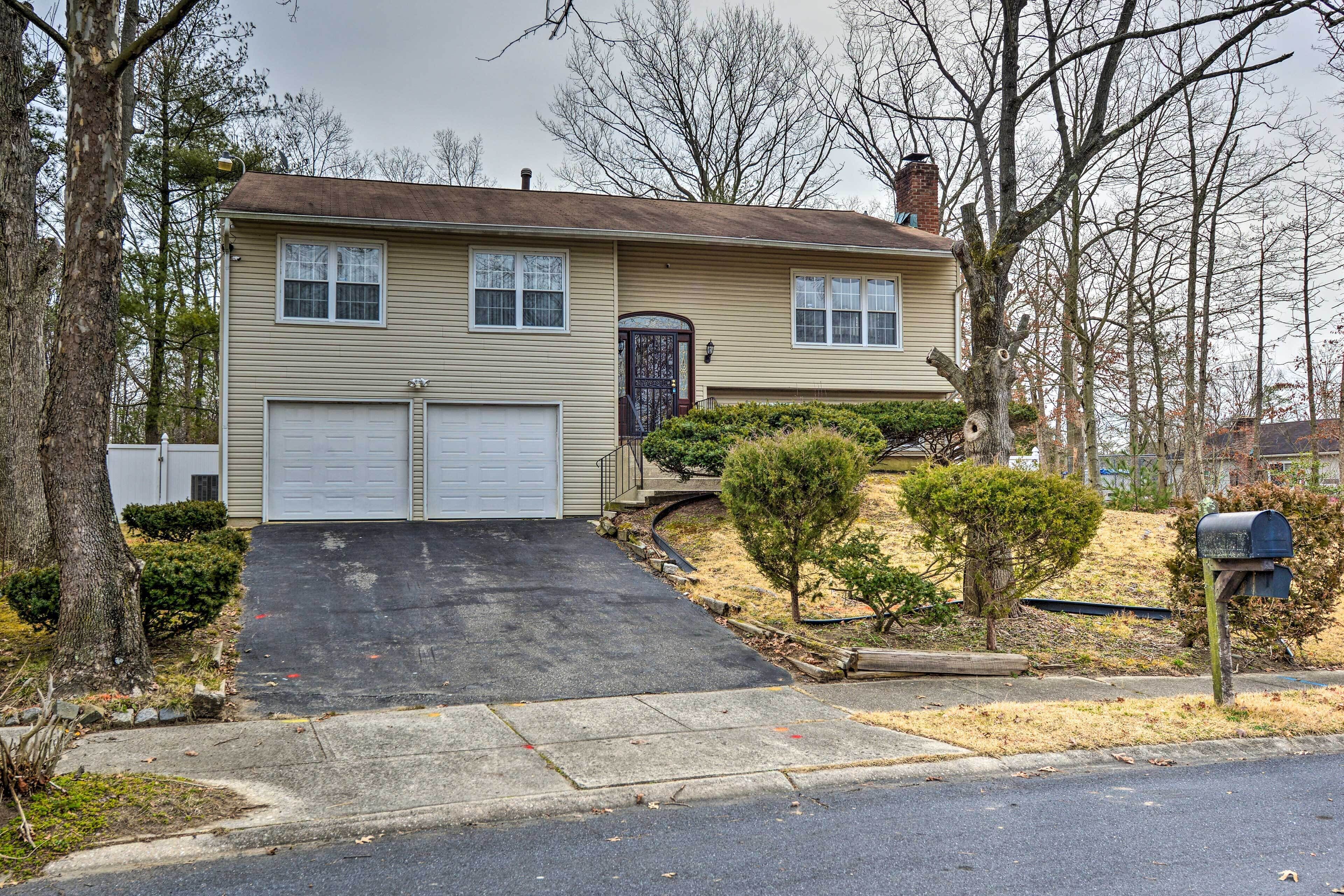 A two-story house with a garage, a front porch, and a mailbox.