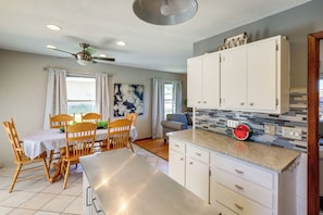 A kitchen with white cabinets, a granite countertop, and a ceiling fan. - Great for Families! Omaha Getaway w/ Yard & Deck (Omaha)