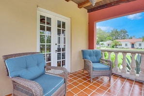 A covered patio with two wicker chairs, a white door, and a view of a house in the background. - 5 Mi to Anna Maria Island! Family Getaway w/ Pool (Bradenton)