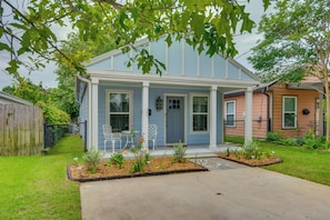 A single-story house with a porch, a fenced yard, and a small garden area. - Downtown Gem: Walk to Restaurants & Palafox St! (Pensacola)