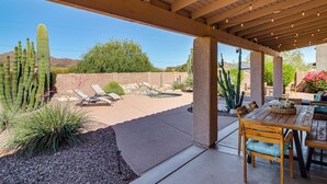 A covered patio with a table and chairs, a pool, and cacti. - Saguaro Sanctuary: Tucson Home w/ Outdoor Oasis (Tucson)