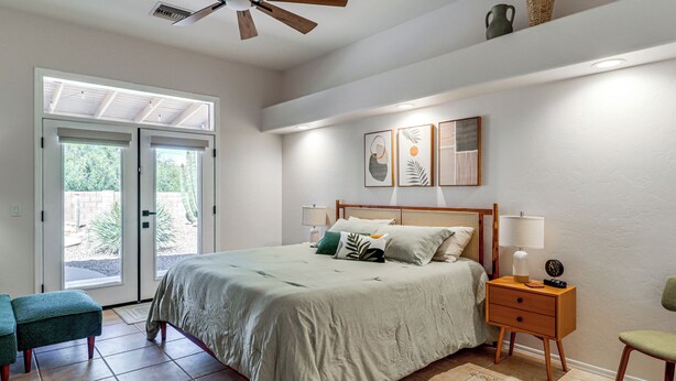 A bedroom with a bed, bedside tables, a bench, and a ceiling fan. - Saguaro Sanctuary: Tucson Home w/ Outdoor Oasis (Tucson)