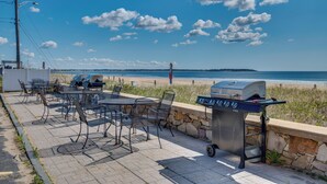 A patio with outdoor seating and a grill, overlooking a beach. - Steps to Beach! OOB Studio w/ Grill Access (Old Orchard Beach)