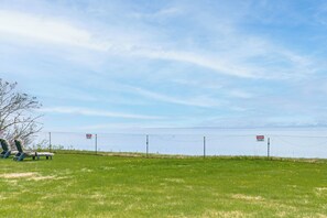 A fenced outdoor area with lounge chairs and a clear sky. - 6 Mi to Kenai Beach! Cozy Ocean-view Escape (Kenai)
