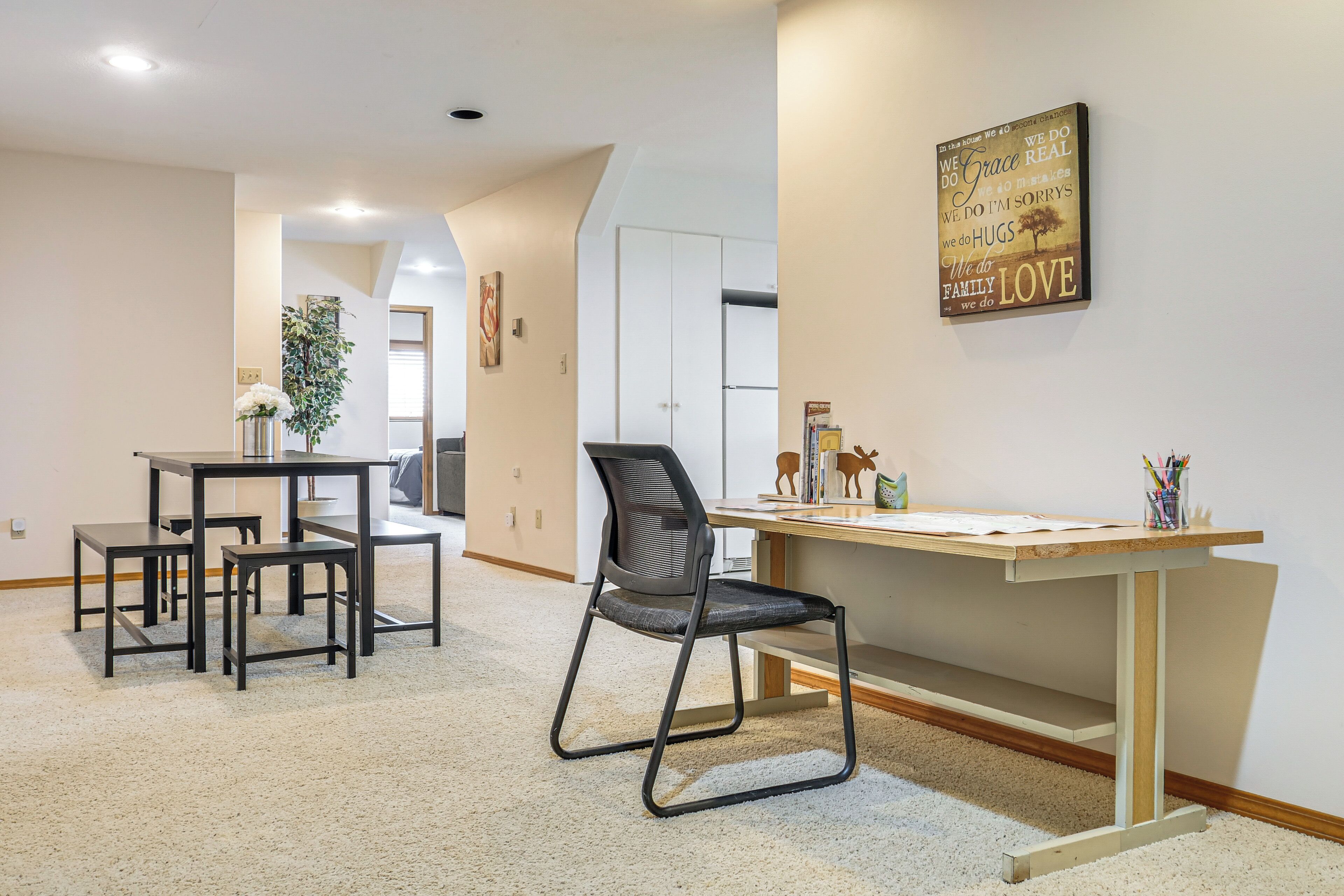 A modern interior with a dining area, a desk, and a chair.