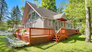 Eine Holzhütte mit einer Terrasse, einer Veranda und einem Steinfundament.
