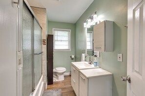 Un baño con ducha, inodoro, lavamanos y tocador.