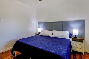 A single bed with a headboard, two bedside tables, and a nightstand with a lamp. - Suburban Sanctuary: Magnolia Home w/ Backyard! (Magnolia)