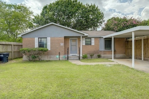 A single-story house with a covered porch, a front door, and a small front yard.