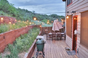A wooden deck with a grill, outdoor furniture, and string lights. - Spacious Glenwood Springs Getaway w/ Game Room! (Glenwood Springs)