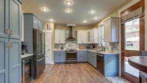 A kitchen with wooden flooring, built-in appliances, and a window with a view.