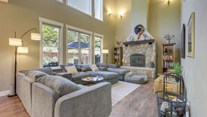 A spacious living room with a sectional sofa, a fireplace, and a bookshelf.