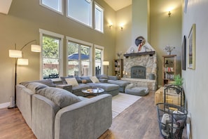 A spacious living room with a sectional sofa, a fireplace, and a bookshelf. - Spacious Glenwood Springs Getaway w/ Game Room! (Glenwood Springs)