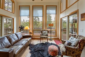 A cozy living room with a leather sofa, patterned armchair, and a rug. - Wallowa Lookout: Scenic Retreat w/ Hot Tub (Joseph)