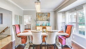 A dining area with a table, chairs, and a chandelier.