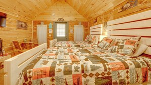A log cabin room with a bed, a chair, a table, and a window. - Near White River Fishing! Studio Cabin w/ Grill (Fifty-Six)