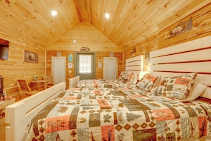 A log cabin room with a bed, a chair, a table, and a window. - Near White River Fishing! Studio Cabin w/ Grill (Fifty-Six)