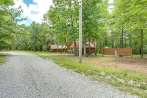 A gravel path leading to a cabin in a wooded area. - Near White River Fishing! Studio Cabin w/ Grill (Fifty-Six)