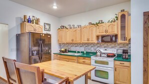 Una cocina con armarios de madera, un refrigerador de acero inoxidable, un microondas y una estufa.