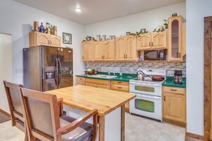 Una cocina con armarios de madera, un refrigerador de acero inoxidable, un microondas y una estufa.